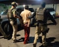 federal agents escort a handcuffed man