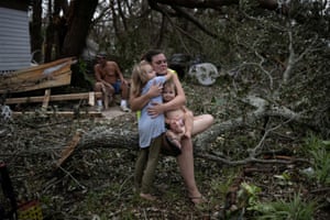 Tiffany Miller is embraced by her daughter Desilynn as she holds her one year old godchild Charleigh, after the family returned to their destroyed home in the aftermath of Hurricane Ida.