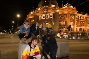 Two young revellers pose for photographs in front of Flinders Street railway station to celebrate the end of lockdown.