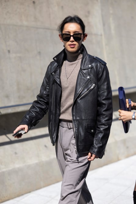 A woman in a black leather jacket and sunglasses.