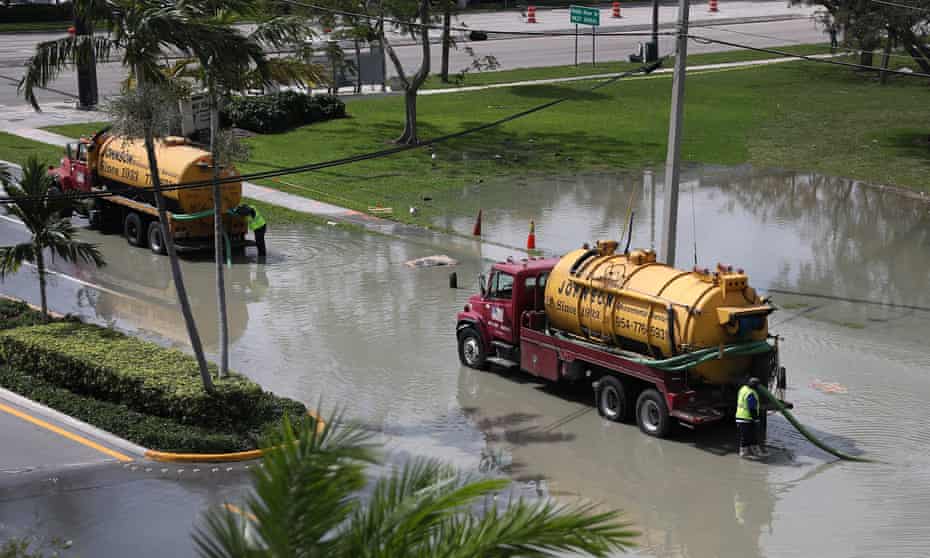 Workers use a vacuum truck to suck up sewer water that flooded the area at George English park after a sewer main broke in February 2020 in Fort Lauderdale, Florida.
