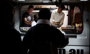 Homeless people line up at a food van in Green Park, Darlinghurst