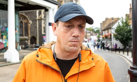 Steven Grimmond in Uxbridge town centre, wearing baseball cap and orange jacket