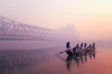 Fishers haul nets into their boat in the Hooghly River in Bengal