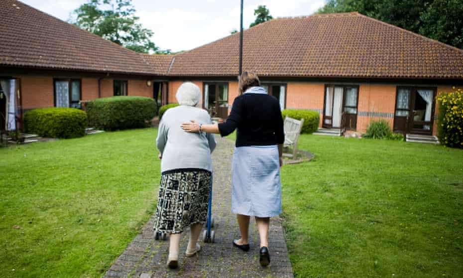Care home worker looking after elderly resident