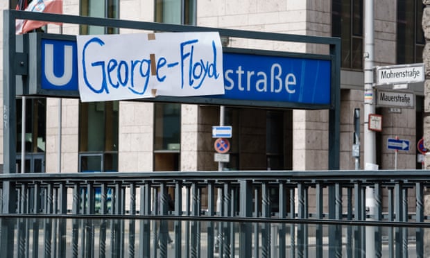 Campaigners cover up the name of Mohrenstrasse station in Berlin with a George Floyd banner.