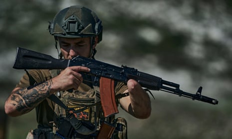 A Ukrainian soldier, code name Ara, who lost his hand a year ago in a battle with the Russian troops close to Bakhmut, holds his machine gun at the front line near Bakhmut, Donetsk region, Ukraine, Tuesday, Aug. 15, 2023. (AP Photo/Libkos)