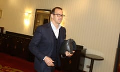 Křetínský walking with a leather bag in his hand and smiling at the camera