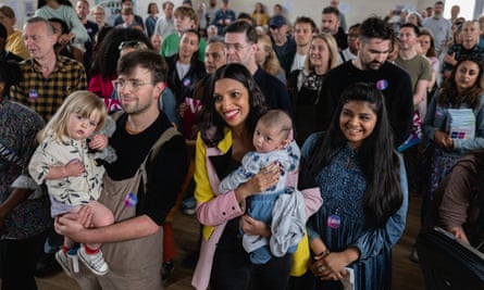 Faiza Shaheen holding a baby surrounded by people in a church hall
