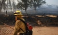 A firefighter in protective clothing manages a fire line in Fresno County, California