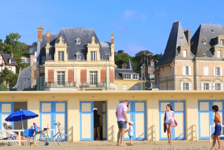 Beach huts on Les Planches Promenade Savignac with 19th-century villas behind.