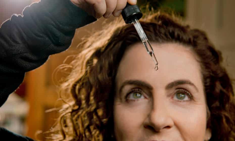 Ayelet Waldman with a pipette of drugs over her forehead