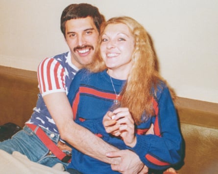 Freddie Mercury sitting with his arms around Mary Austin.
