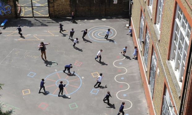 School children playing in a school playground in London.