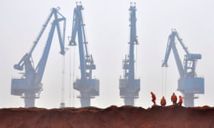Workers remove the cloth covering the iron ore from Australia while they prepare for transporting at a port in Tianjin municipality March 29, 2010. 