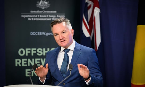 Chris Bowen wearing a blue suit and tie speaks to the media from a lectern