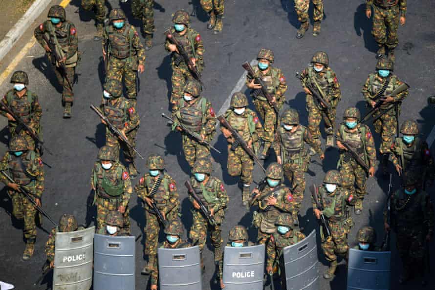 Myanmar soldiers walk along a street during a protest against the military coup in Yangon