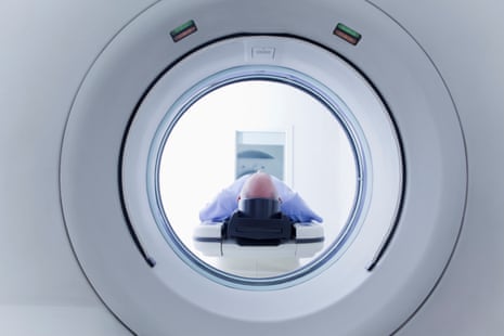 Patient lying down on CT scanner - stock photo