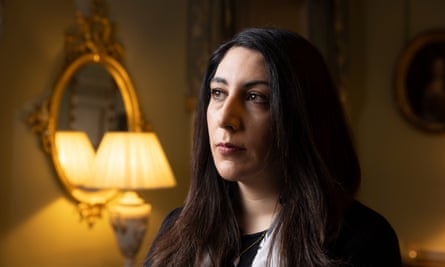 Photograph of Nadia El-Nakla looking off camera, with a glowing table lamp in the background