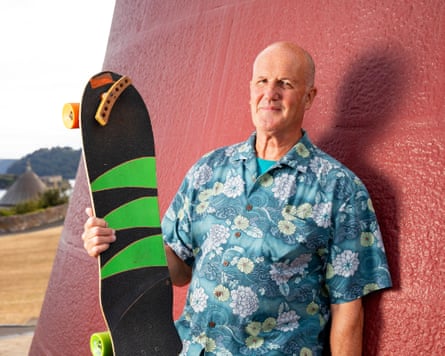 Darren standing against a wall, holding a skateboard.