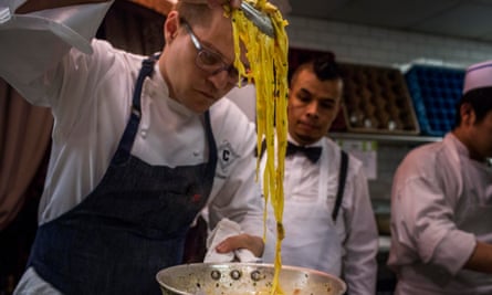 In the middle of busy dinner rush Chef William Cox, center, checks a pasta dish at Carbone in Manhattan, September 2015.
