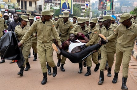 Ugandan police officers detain a civilian in Kampala demonstrating against President Museveni’s election victory