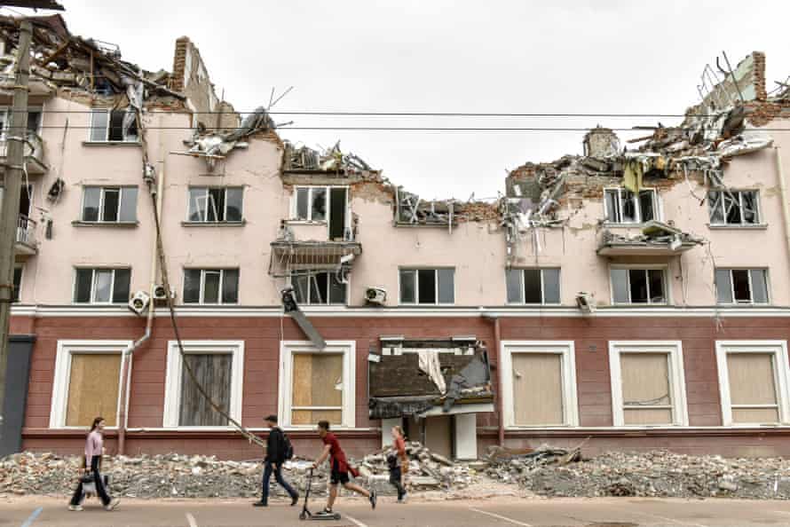 People walk near the remains of hotel Ukraine, destroyed in a Russian missile strike in Chernihiv city.