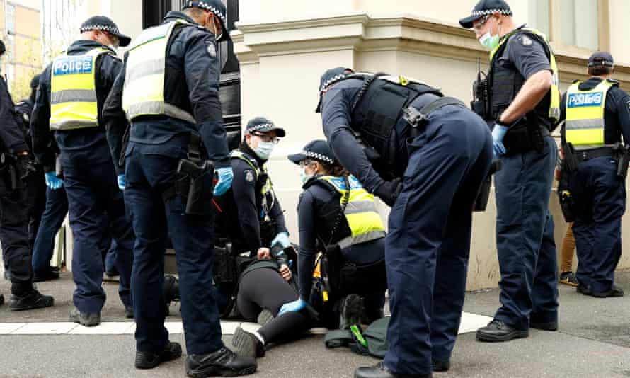 Police detain a women in Melbourne near the CFMEU building on Wednesday morning.