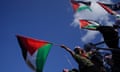 A group of people at a protest hold up Palestinian flags