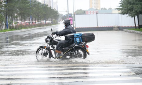 A courier battles heavy rain in Changchun, Jilin province, in north-east China, in September 2020.