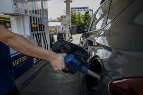 A person refuels a vehicle at a petrol station in NSW.