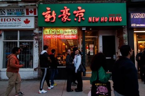 People pose for pictures in front of a Chinese restaurant.