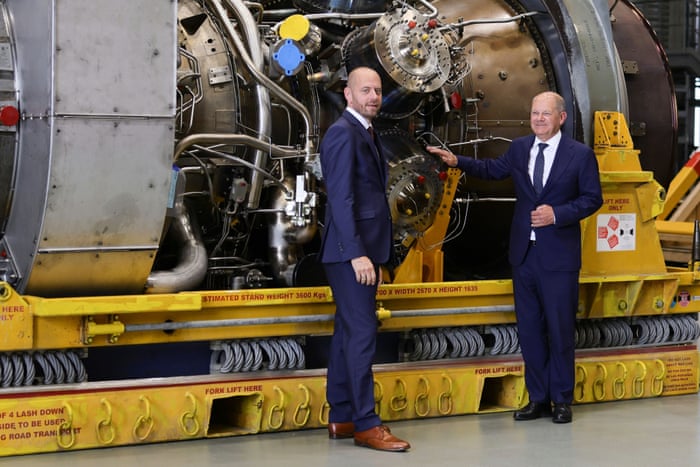 German Chancellor Olaf Scholz (R) and Siemens Energy Chairman Christian Bruch look at the Siemens gas turbine intended for the Nord Stream 1 gas pipeline in Russia today.
