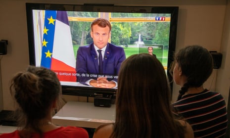 Members of the public watching Macron give a previous address, in June.