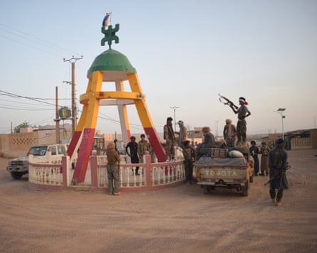 Rebels stand holding guns at a monument