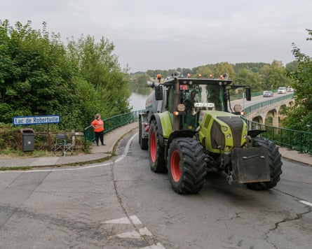 A tractor on a road next to Lake Robertsville