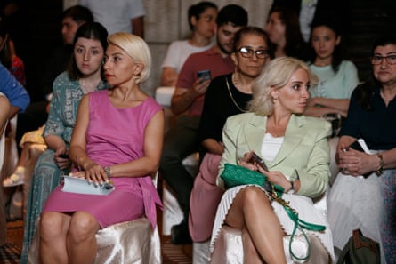 Spectators watch models with disabilities on the catwalk wearing tailored-made adaptive clothes.