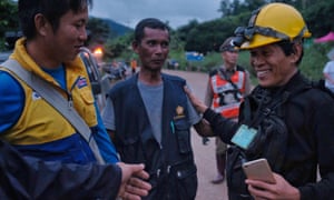 Rescue workers along the main road leading to Tham Luang Nang Non cave as the first 2 ambulances carrying 2 boys pass