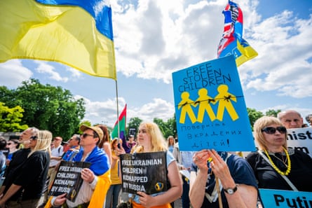 Protesters wave Ukrainian flags and hold placards saying ‘free stolen children’ and ‘free Ukrainian children kidnapped by Russia’