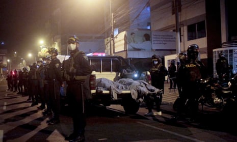 Police officers stand guard near two bodies outside of a nightclub in Lima, Peru.