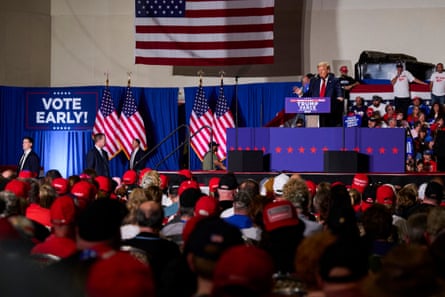 a man in a suit speaks to a crowd of people