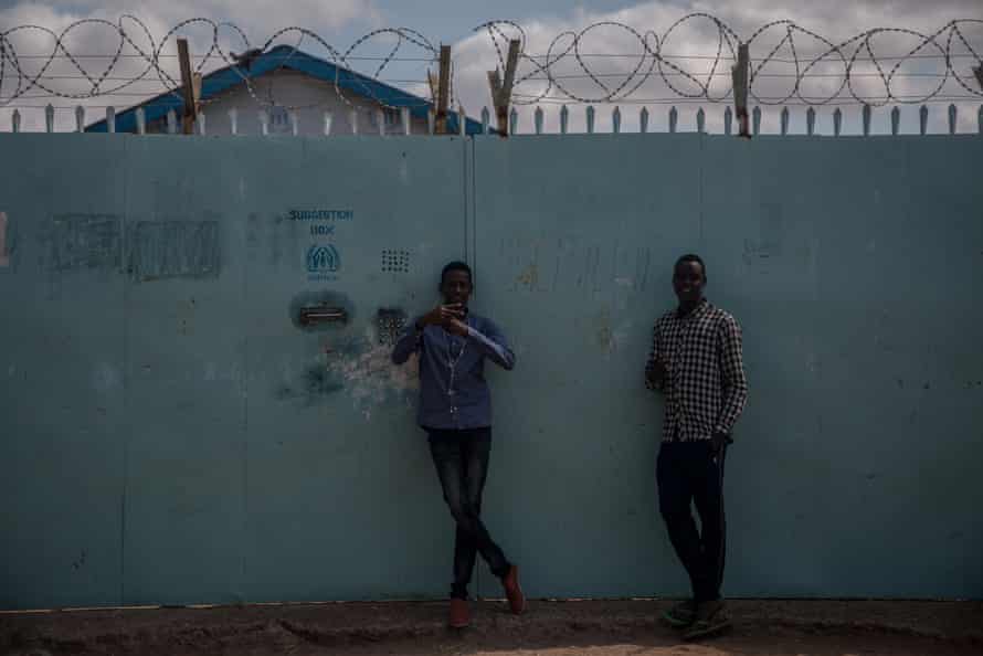 Young men stand in front of a UNHCR field office in Dadaab refugee camp, Kenya