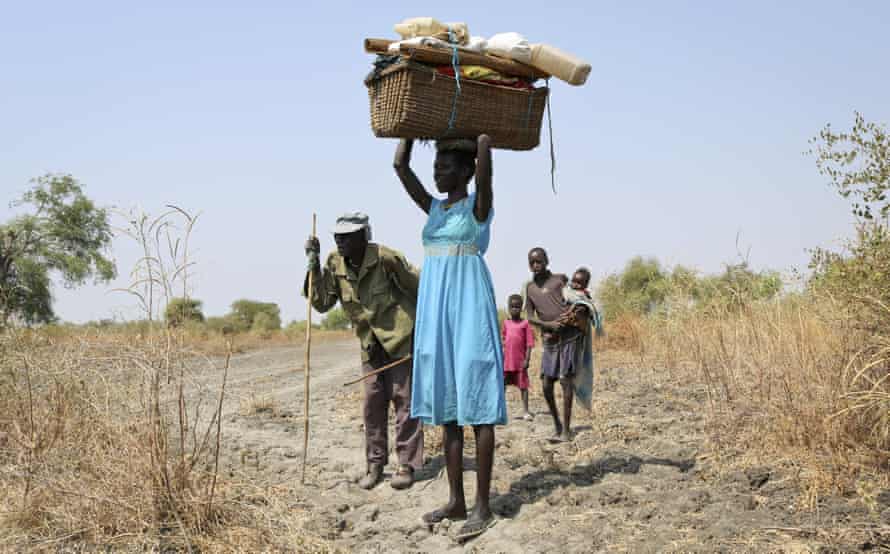 A family displaced by fighting walk into Akobo town, one of the last rebel-held strongholds in South Sudan, after government troops attacked their village.