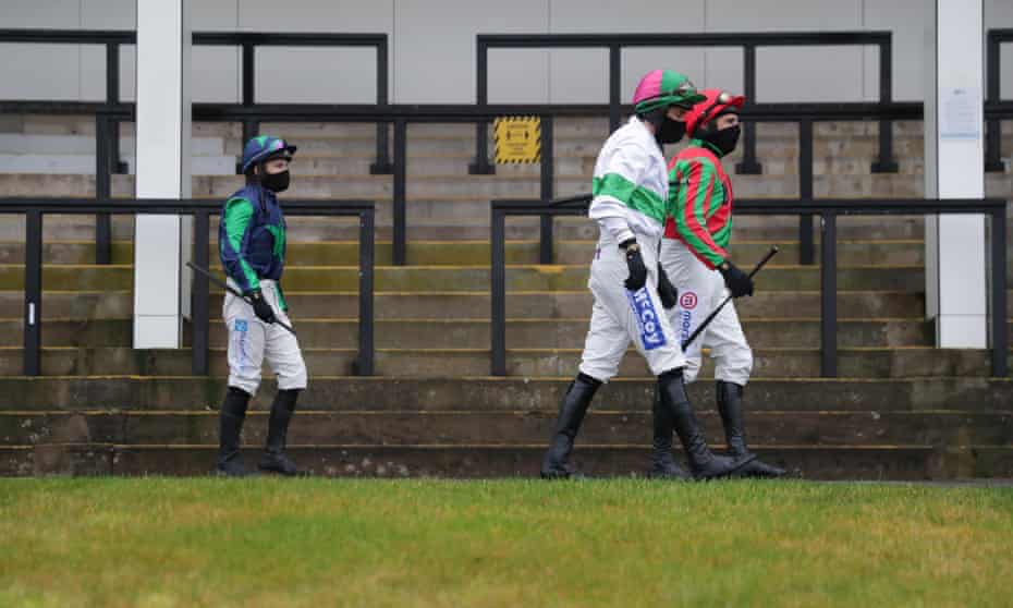Jockeys pass an empty grandstand at Chepstow in January. The Welsh Grand National is set to be run behind closed doors next Monday.
