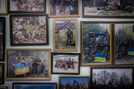 Framed photographs of various Ukrainian army soldiers and combat units on a doctor’s office wall.