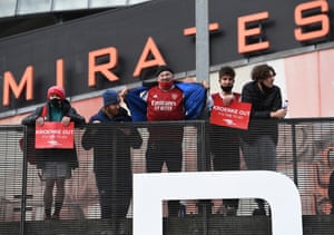Arsenal fans hold banners against owner Stan Kroenke during a protest outside of the Emirates Stadium before the game against West Brom