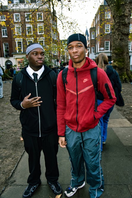 Two young men in casual clothes in a small London Park surrounded by Georgian buildings