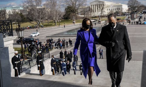 Kamala Harris, in a purple coat and dress by Christopher John Rogers, with her husband, Doug Emhoff, at the inauguration on 20 January. 