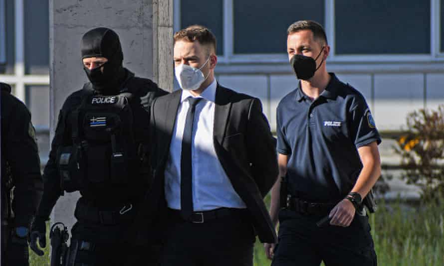 The accused being escorted to court by police.