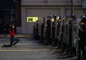 A man gets on his knees in front of police officers during a protest against the death in Minneapolis police custody of African-American man George Floyd, in St Louis, Missouri, U.S. June 1, 2020.